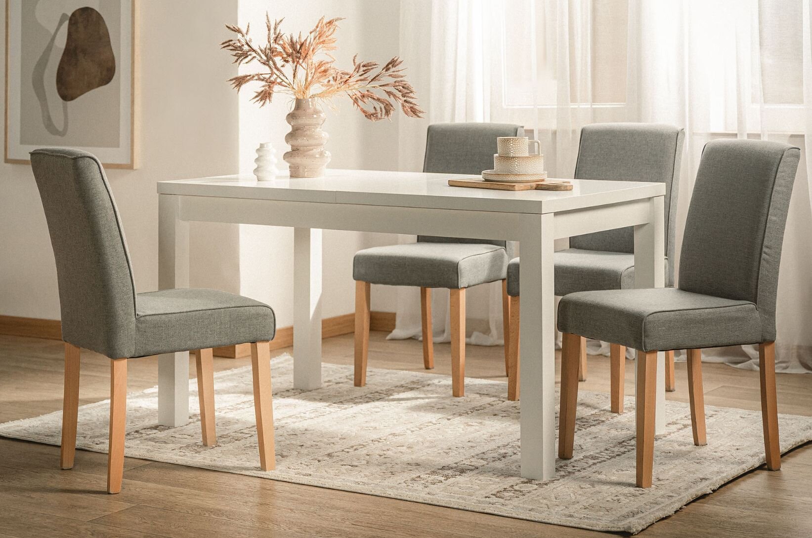 Světlý obývací pokoj se stolem a židlemi pro celou rodinu. 