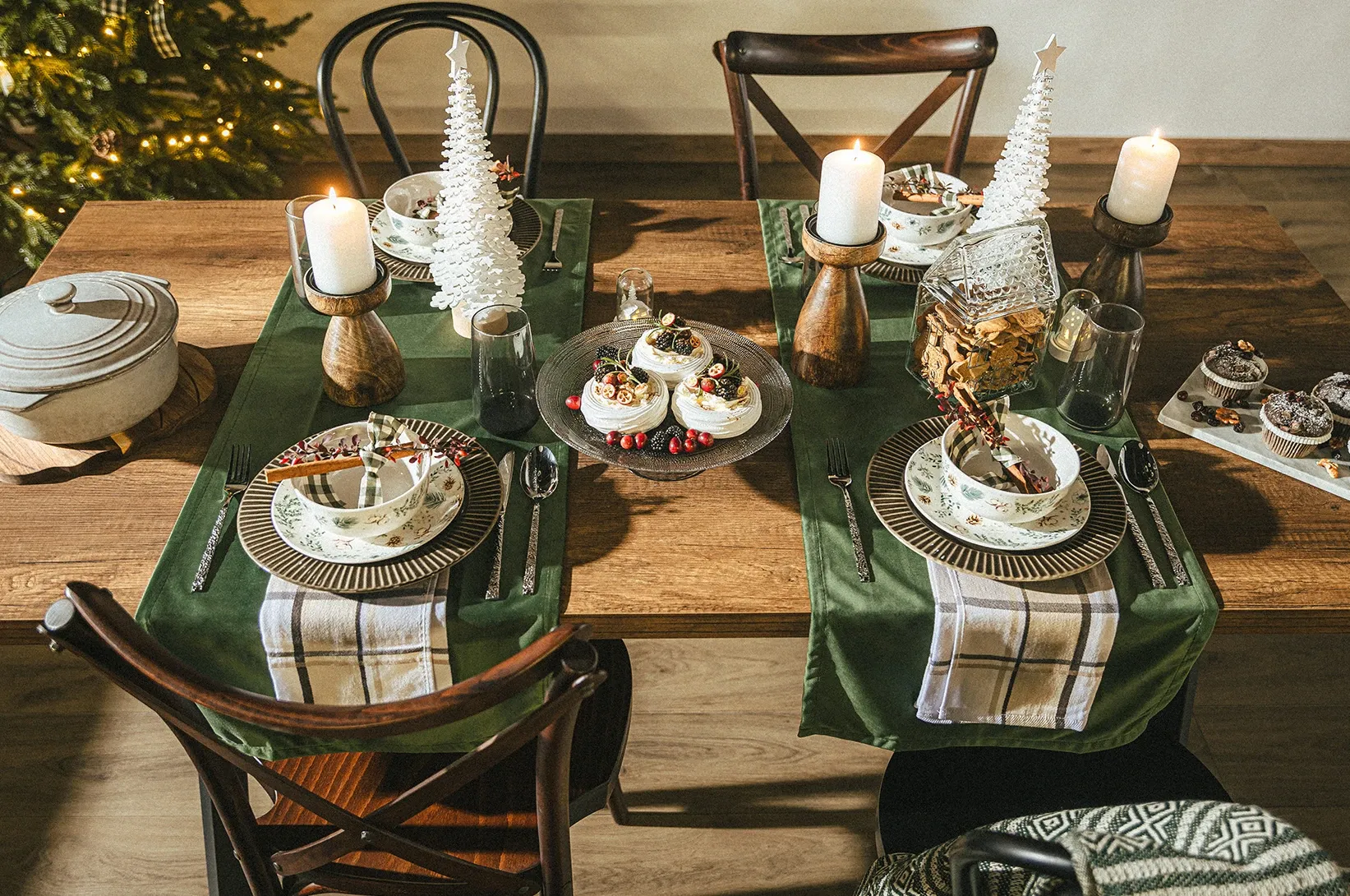 Vánoční stůl prostřený nádobím a vánočními dekoracemi. 