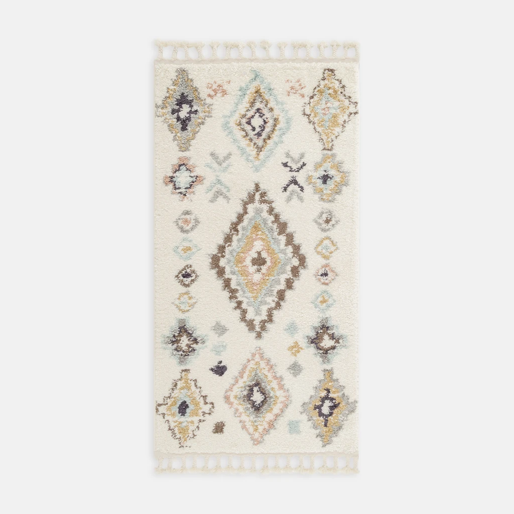 Dywan w stylu boho z geometrycznym wzorem. Kremowe tło, kolorowe akcenty.