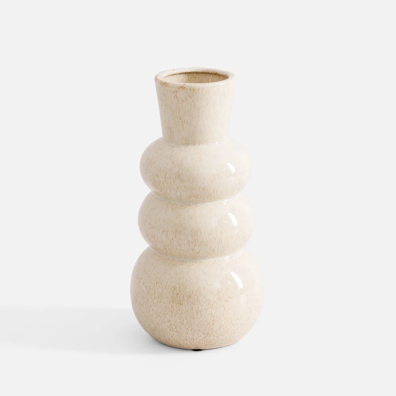 Ceramiczny wazon w kolorze kremowym. Obłości przypominają sylwetkę bałwanka. Nakrapiany drobnymi jasnobrązowymi piegami.