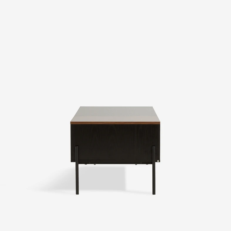 Czarny bok stolika z widocznymi cienkimi nogami zamontowanymi wzdłuż boku mebla