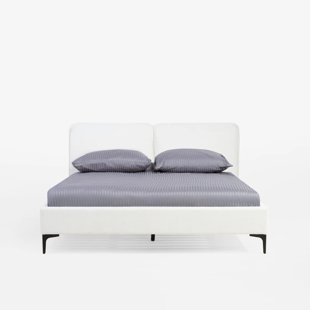 Widok na łóżko od strony szczytu dolnego. Na łóżku materac i srebrzystoszara pościel. Widoczne czarne nóżki.