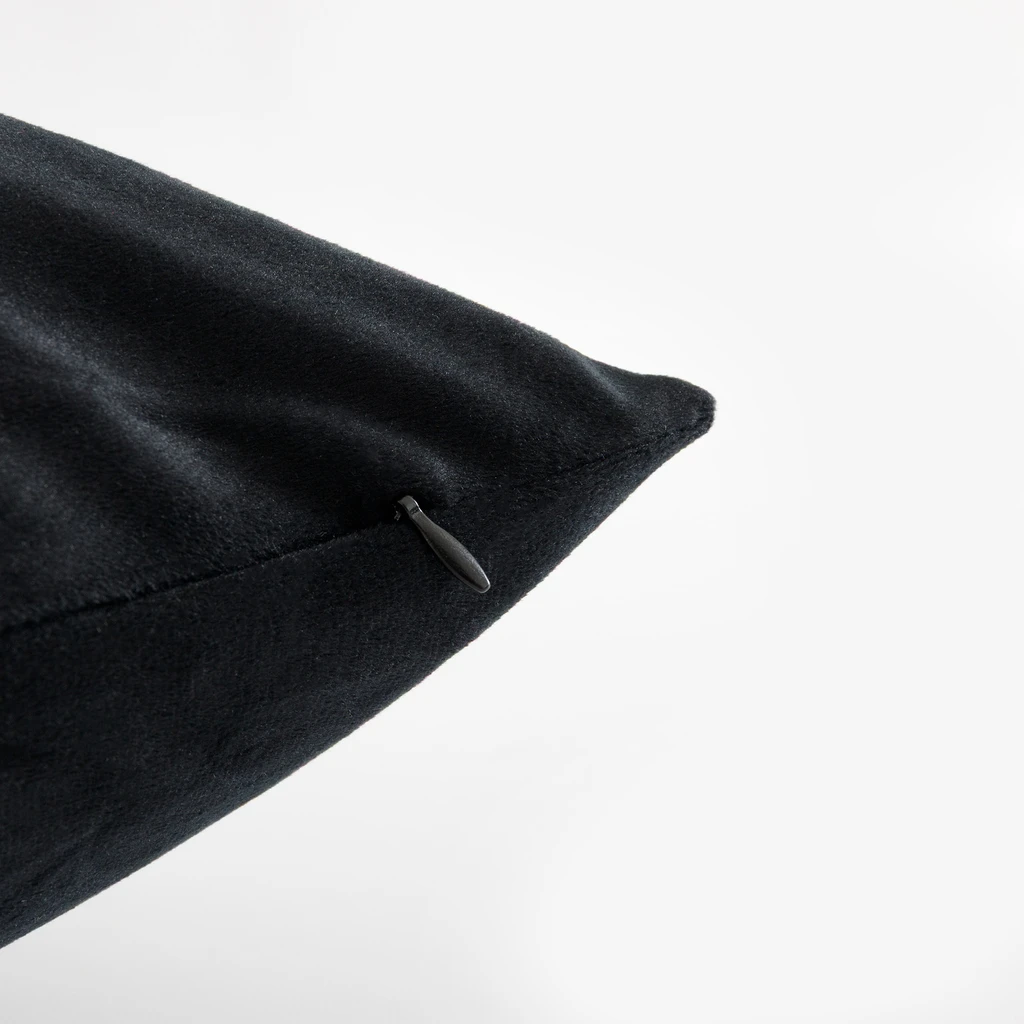 Zbliżenie na róg czarnej poszewki, widoczne staranne wykończenie i uchwyt zamka w kolorze poszewki. 