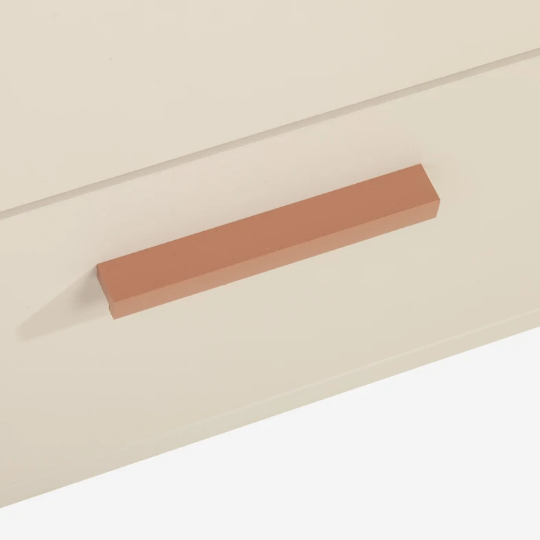 Ciepły odcień uchwytu podkreśla prostą formę szafki z 2 szufladami.