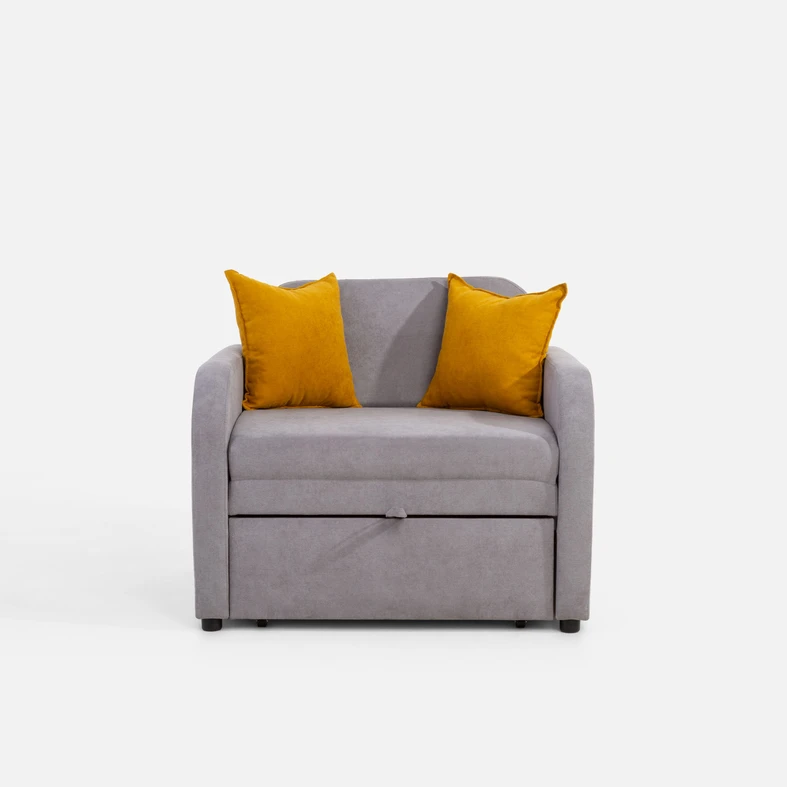 Szara, jednoosobowa rozkładana sofa. Na siedzisku dwie musztardowe poduszki dekoracyjne. 