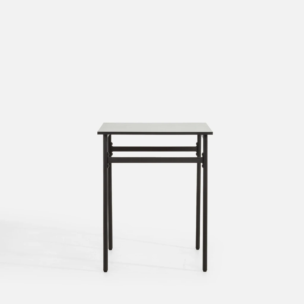 Minimalistyczny, lekki, kwadratowy stół na metalowych nogach.