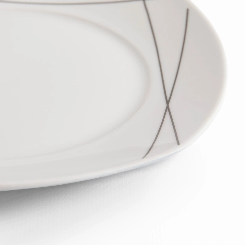 Detal, krawędź białego, porcelanowego talerza, widoczny delikatny geometryczny wzór rysowany cienką, ciemnoszarą linią.