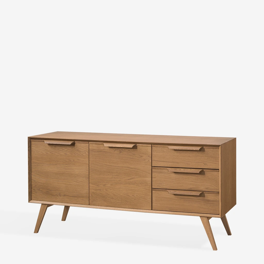 Komoda w stylu retro z trzema szufladami i czterema wnękami ukrytymi za drzwiczkami, na wysokich, ukośnych nóżkach, w ciepłym kolorze jasnego drewna.