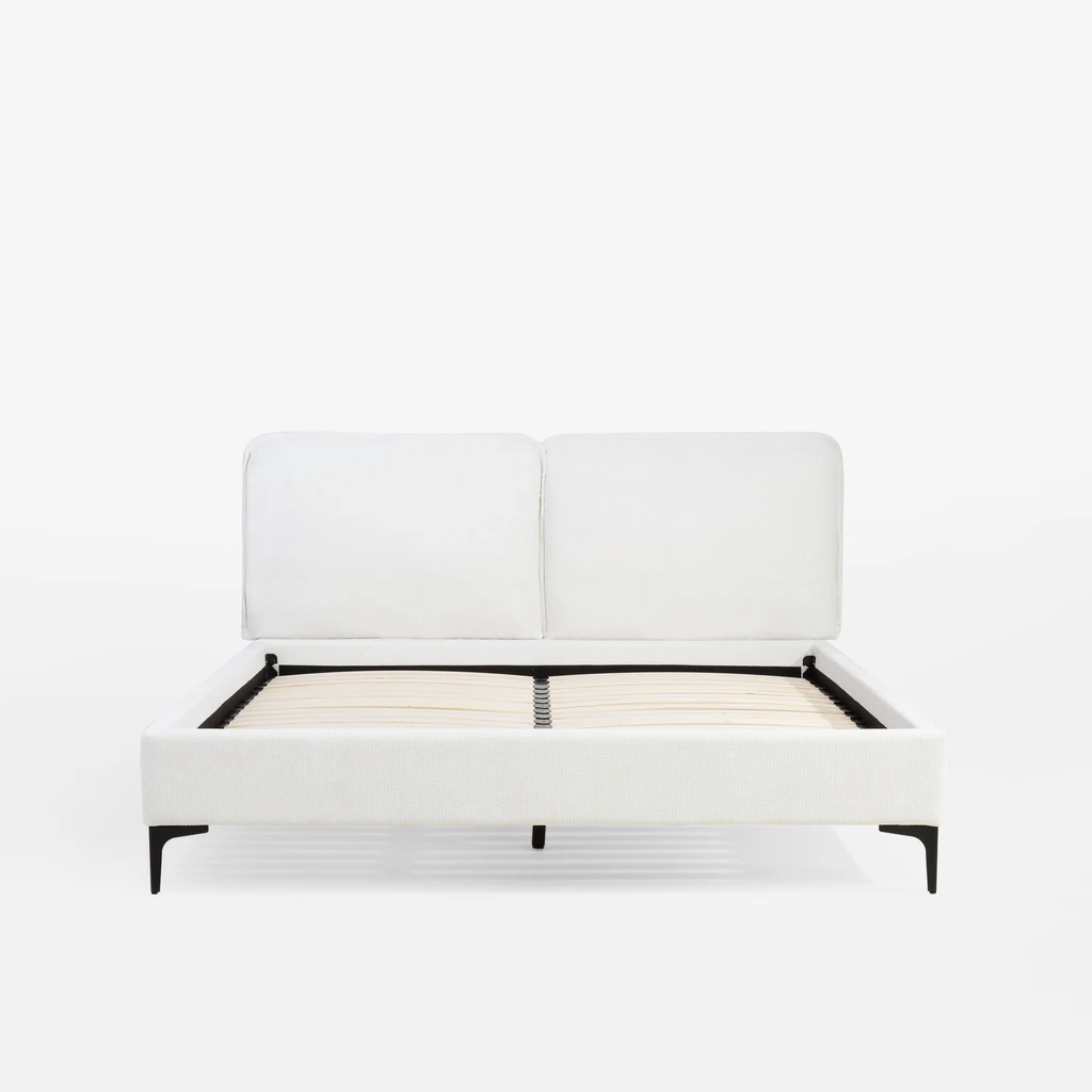 Widok na łózko od strony szczytu dolnego. Wysoki, tapicerowany zagłówek ma formę dwóch pionowych, połączonych części.