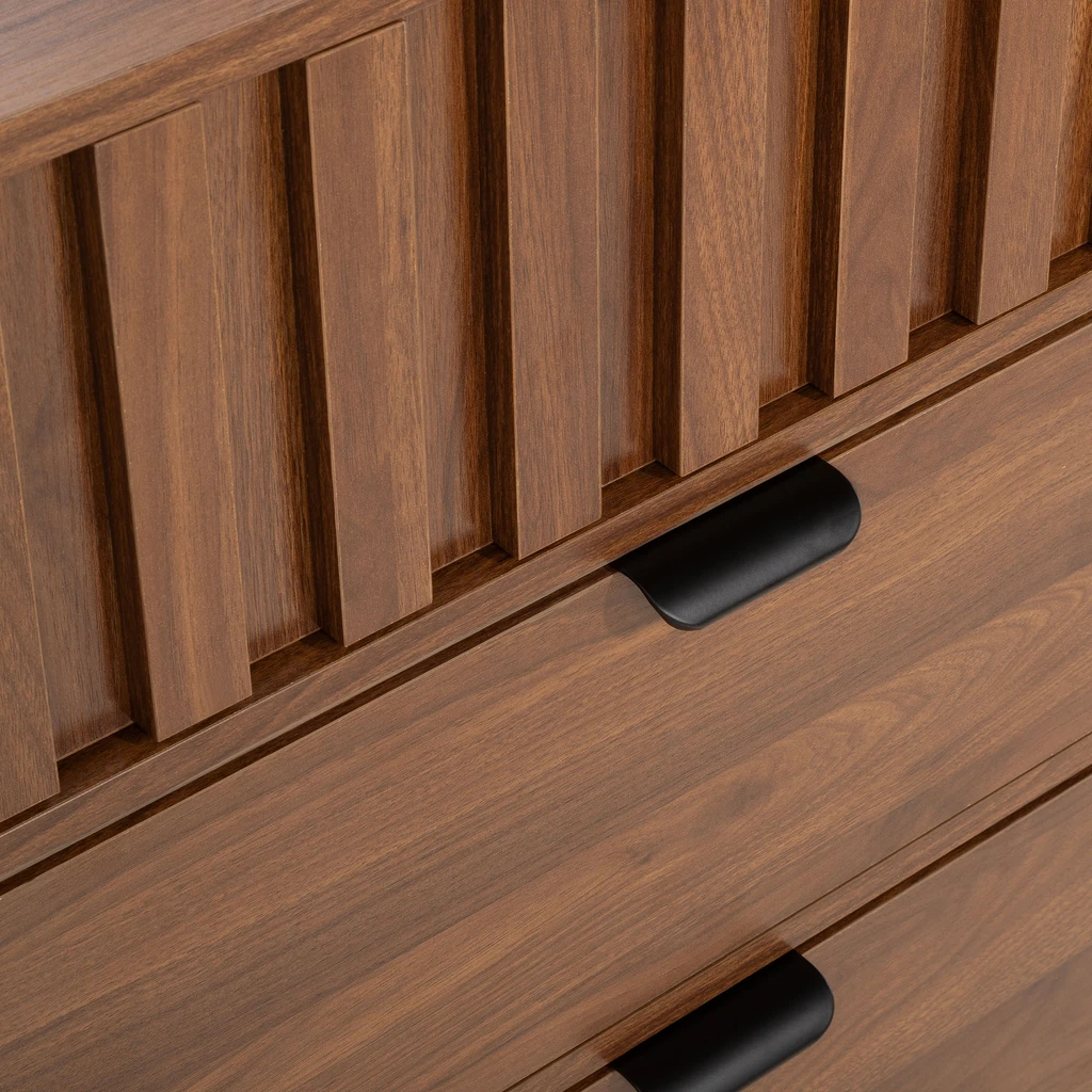 Detal, widok fragmentu górnej szuflady z ryflowaniem i czarnymi uchwytami