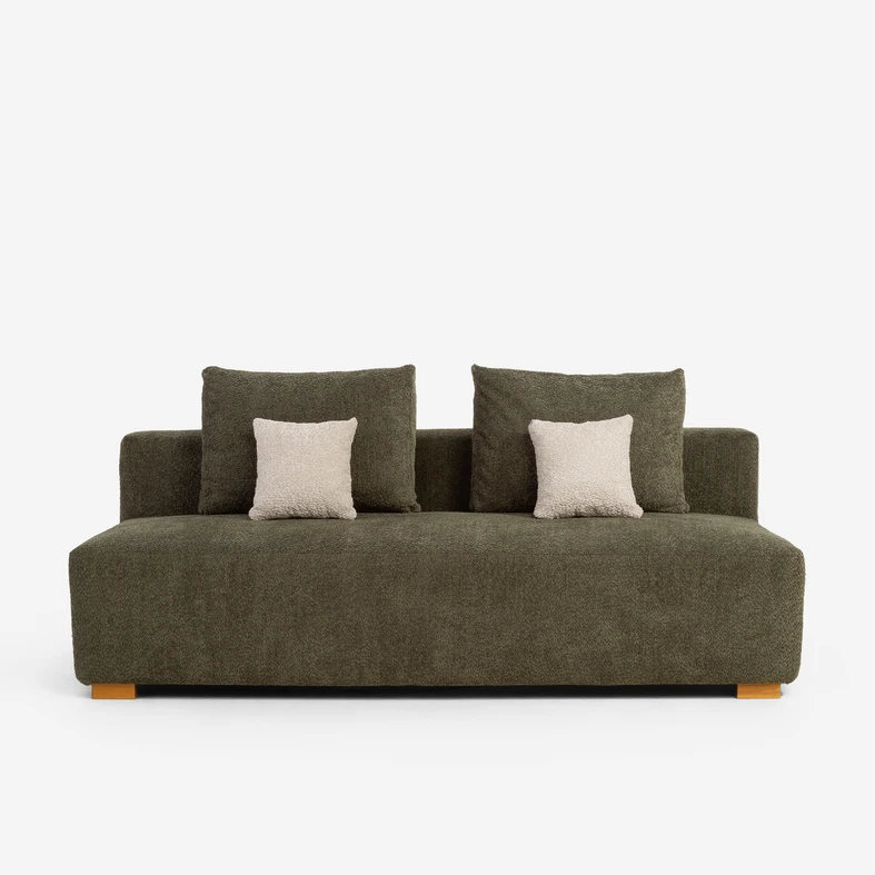 Zielona sofa z poduszkami oparciowymi w tej samej tkaninie i dwoma małymi beżowymi