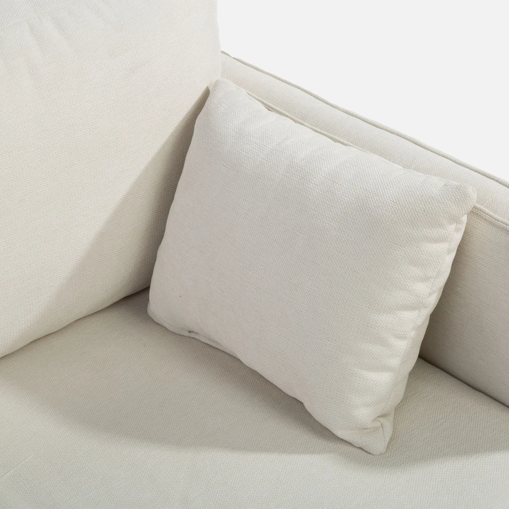 Detal, drobna dekoracyjna poduszka pokryta tą samą tkaniną co sofa.