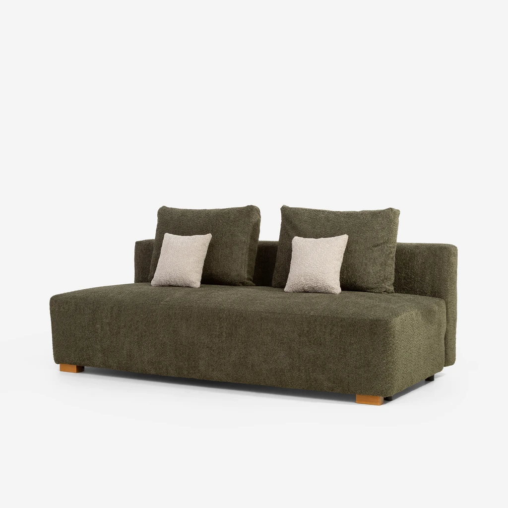 Zielona sofa z poduszkami oparciowymi w tej samej tkaninie i dwoma małymi beżowymi