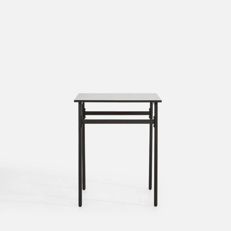 Minimalistyczny, lekki, kwadratowy stół na metalowych nogach.