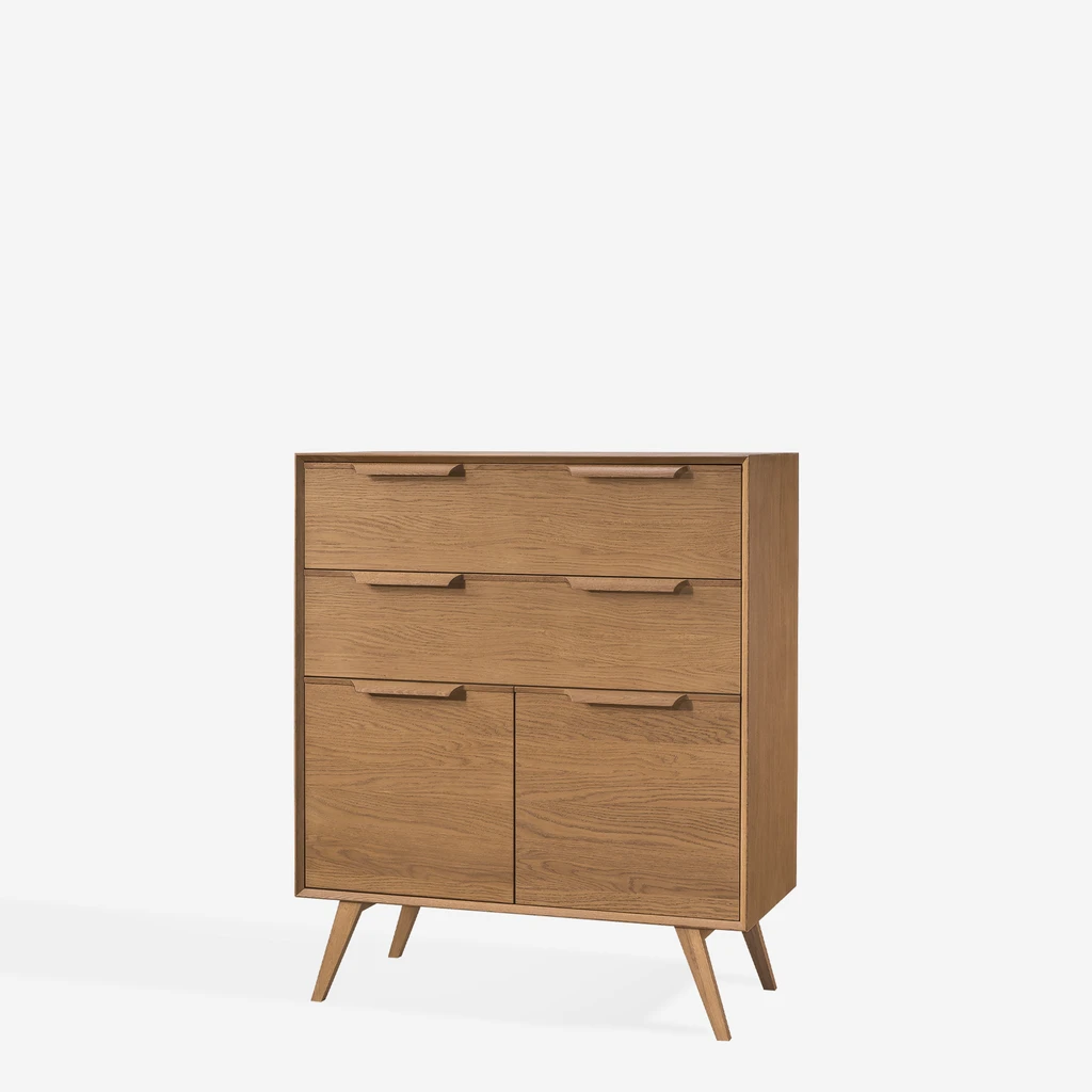 Komoda w stylu retro z dwoma dużymi szufladami i czterema wnękami ukrytymi za drzwiczkami, na wysokich, ukośnych nóżkach, w ciepłym kolorze jasnego drewna.