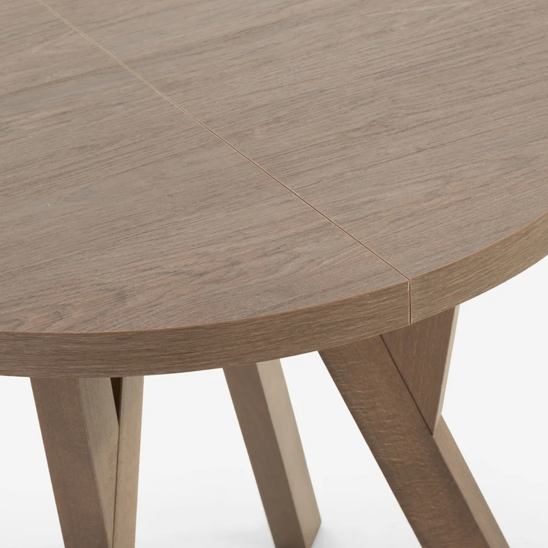 Detal, zaokrąglone brzegi stołu w kolorze ciemnego drewna.