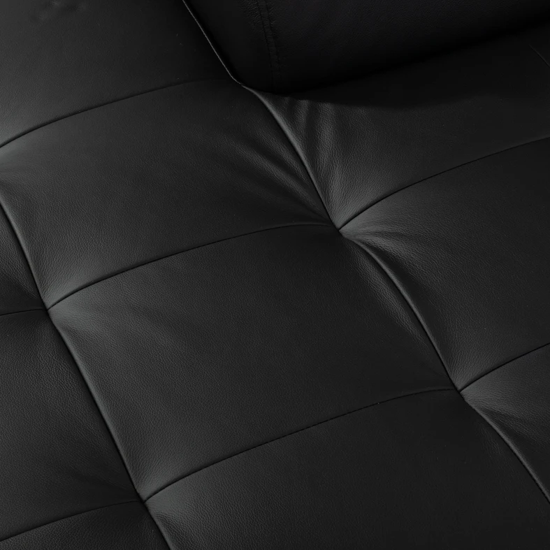 Fragment skórzanego czarnego siedziska z pikowaniem.