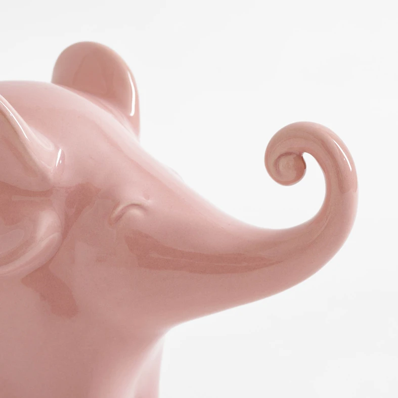 Różowy słonik z radośnie uniesioną trąbą.